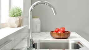 Silver kitchen tap on marble counter